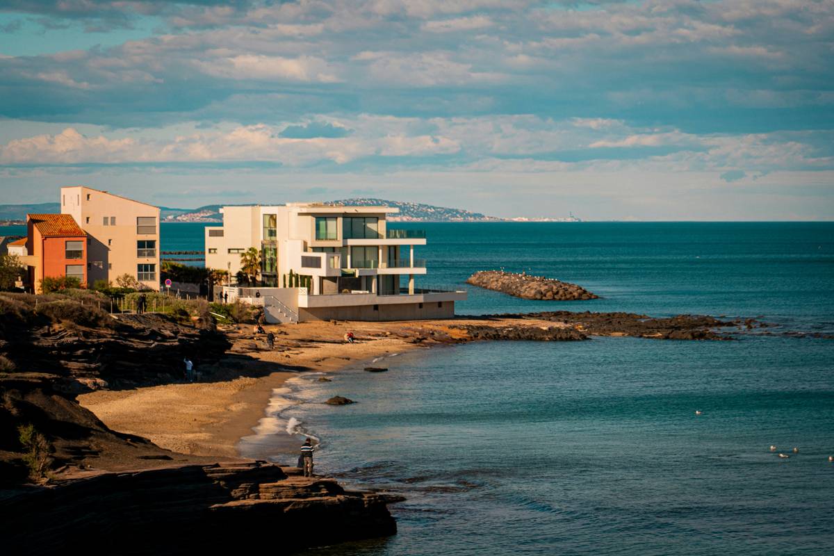 Interior view during a modern oceanfront home tour showing smart lighting and ocean vista